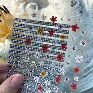 Close-up of floral and plaid nail stickers with intricate flower and stripe patterns