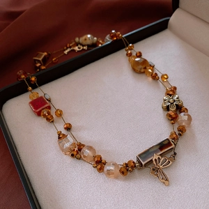 Close-up of vintage beaded flower necklace with butterfly charms and glass beads
