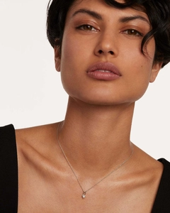 Detail of a gold S925 sterling silver heart lock necklace with a white gemstone on model