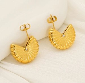 Gros plan de boucles d'oreilles éventail dorées avec texture striée et zircon central