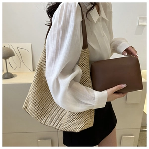 Close-up of beige woven tote bag with brown leather handles and matching clutch pouch