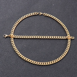 Gros plan d'un ensemble collier et bracelet maille gourmette dorée sur fond noir