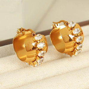 Chunky C-shaped 18K gold plated hoop earrings with oval cubic zirconia on fabric background