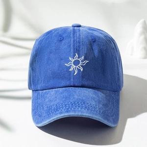 Close-up of Klein blue washed cotton baseball cap with white sun pattern embroidery