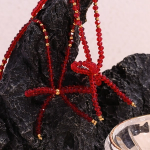 Detail shot of red faceted crystal beads and gold metal accents on handmade jewelry