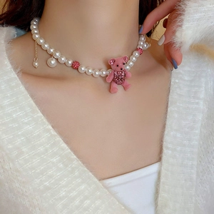 Detailed view of pink flocked bear necklace with faux pearls and sparkling diamond accents