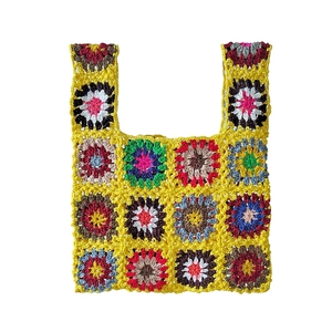 Detailed close-up showing the intricate granny square crochet texture of the handmade bag
