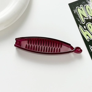 Close-up of a deep wine red banana hair clip with internal teeth on a white surface