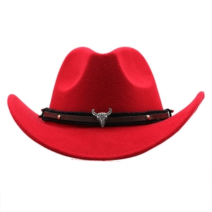 Détail d'un chapeau de cowboy rouge avec emblème tête de taureau et bande en cuir tressé