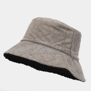 Detail of the reversible bucket hat showing the khaki suede and black fleece lining
