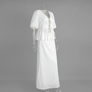 Detail of white cotton two-piece set featuring puff sleeves and tie-front bow design
