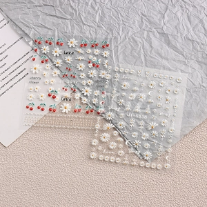 Detail of 5D embossed cherry and daisy nail art stickers showing realistic textures