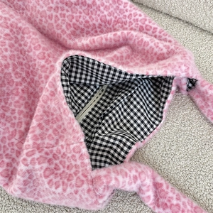 Close-up of pink heart-shaped leopard faux fur tote with check lining and zipper