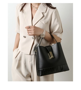 Detail of black bucket bag featuring lychee grain and crocodile embossed leather texture