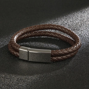 Detail of a brown double-braided leather bracelet with a silver magnetic metal clasp
