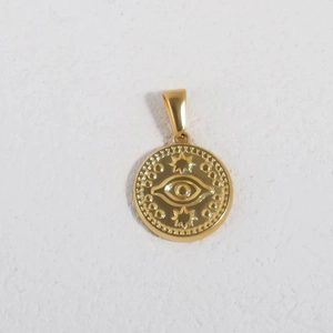 Detailed macro view of a vintage gold 24K plated evil eye pendant with star accents