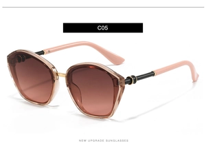 Detail of champagne cat-eye sunglasses featuring pink temples and metallic buckle accents