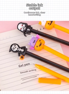 Close-up of Halloween gel pens with skull and pumpkin silicone toppers on notebook