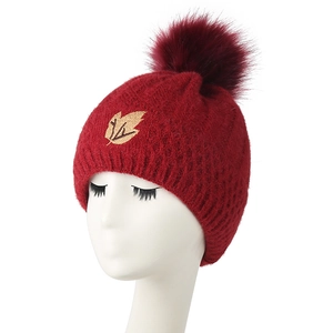 Winter fleece-lined knit beanie in dark red with golden maple leaf and faux fur pompom