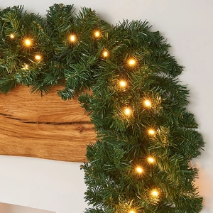 PVC Christmas garland with warm LED lights on a wooden frame for festive decoration
