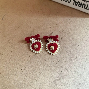 Detail of vintage red flocked heart earrings with bow, gold rose, and faux pearl border