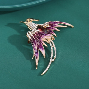 Detailed close-up of Phoenix brooch with purple enamel wings and red crystal center