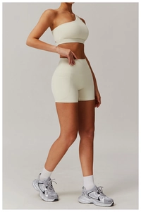 Detail of high-waisted fitness shorts with side pockets and off-shoulder sports bra