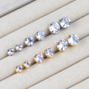 Detailed set of silver and gold zircon stud earrings in various sizes on velvet