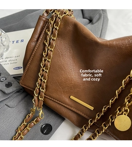 Close-up of brown litchi pattern leather tote bag with elegant gold chain strap detail
