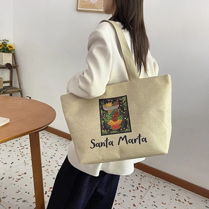 Detail of large beige linen tote bag with Santa Marta tropical artwork on shoulder