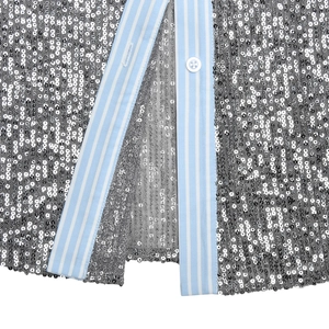 Detailed macro view of silver sequins and light blue striped trim with a white button