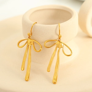 Elegant gold ribbon bow earrings with minimalist pearl design for women on beige stand