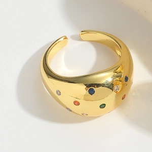 Macro detail of gold open ring featuring colorful inlaid gemstones on polished metal