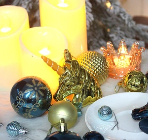 Detail of blue and gold Christmas ornaments featuring a unicorn head and festive baubles