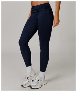 Detail of high waisted yoga pants featuring tummy control ruching in navy blue
