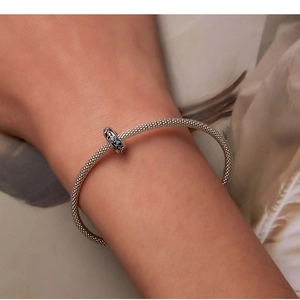Detail of silver mesh bracelet with hollow zircon charm on model wrist