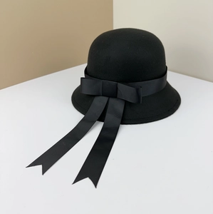 Detailed macro view of black wool felt hat featuring elegant ribbon bow and long streamers