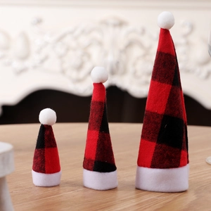Set of three buffalo plaid mini Christmas hats in different sizes on wooden table