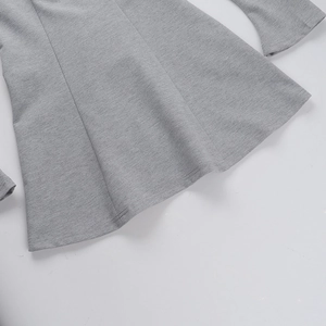 Detail view of heather gray knit fabric showing the hemline and sleeve cuff texture