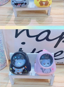 Detail of cute mini backpack keychains with cartoon characters on a white wooden bench