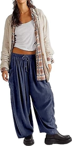 Détail d'un pantalon sarouel bleu marine porté avec un blazer beige et une chemise