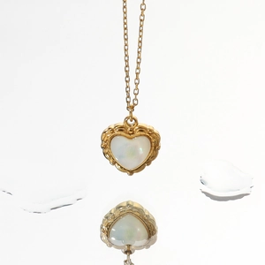 Gros plan détaillé du collier pendentif cœur doré avec incrustation en nacre
