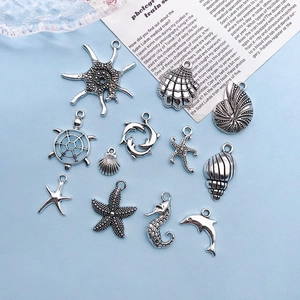 Macro view of 12 antique silver ocean-themed charms including starfish and sea turtles