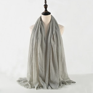 Close-up of grey crinkled cotton linen scarf showing frayed edges and soft texture