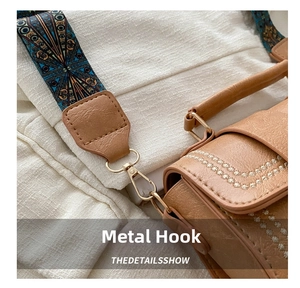 Close-up of brown PU leather bag with bohemian patterned strap and gold metal hook hardware