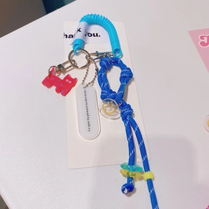 Gros plan du porte-clés en corde bleue avec pendentif chat rose et étiquette en français