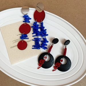Vue détaillée de boucles d'oreilles fleurs bleu Klein et pendentifs rose rouge
