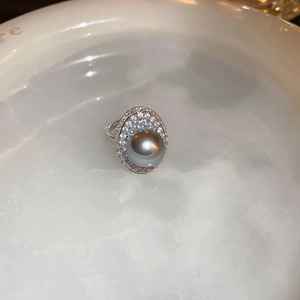 Macro detail of French retro silver ring with large grey pearl and micro-pave zircon setting