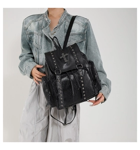Detailed close-up of a black PU leather backpack with silver studs and cross hardware