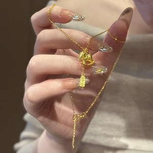 Detailed close-up of 24K gold plated rocking horse pendant and Ping An tag on a necklace